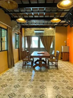 a dining room with a wooden table and chairs at Baibon1 Boutique House Thalang Phuket in Ban Na Nai