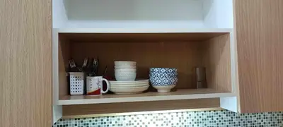 a shelf with cups and plates and utensils at Naithon Beachfront Condotel in Nai Thon Beach