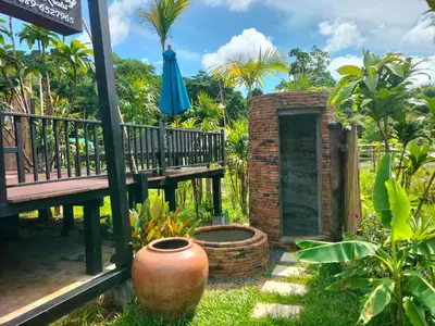 a patio with a bench and an umbrella at Baan Koh Kwang Pool Villa Krabi in Krabi town
