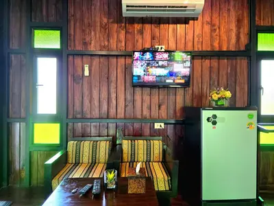 a room with a couch and a tv on a wall at Baan Koh Kwang Pool Villa Krabi in Krabi town