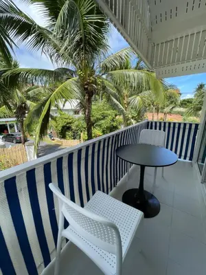a balcony with a table and chairs and palm trees at Kata Hillside Hideaway in Kata Beach
