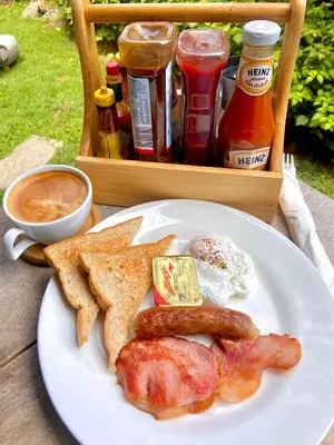 a plate of breakfast food with eggs sausage and toast at Kata Hillside Hideaway in Kata Beach