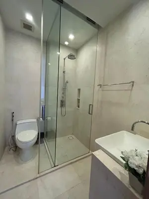a bathroom with a shower and a toilet and a sink at 2 Bedroom Beachfront Apartment With Sea Views in Mai Khao Beach