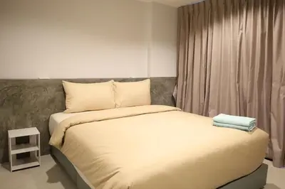 a bed with two towels on top of it in a room at Y House Patong in Patong Beach