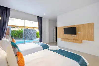 two beds in a hotel room with a tv at Sasi Pool Villa Phuket in Rawai Beach