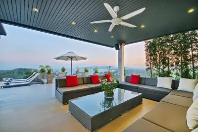 a living room with a couch and a ceiling fan at Villa Amonteera in Surin Beach