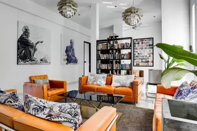 a living room with orange furniture and a book shelf at Villa Amonteera in Surin Beach