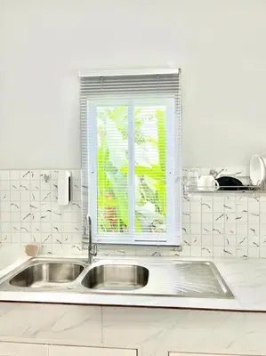 a white kitchen with a sink and a window at Lay Back Villa C2 with Kitchen & High speed Internet in Krabi town