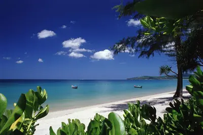 a beach with two boats in the water at 1 Bedroom Pool view at Diamond Condo, Bangtao in Bang Tao Beach