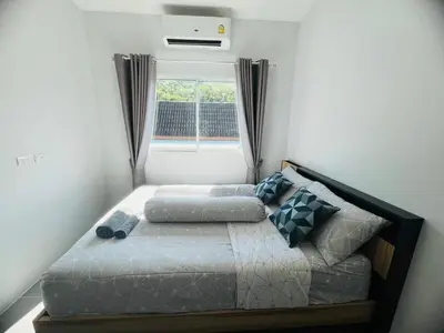 a bed in a room with a window and a bed sidx sidx sidx at Arin Townhome @Bangtao in Ban Thalat Choeng Thale