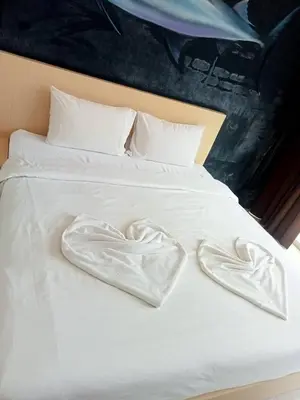 a bed with two white towels in the shape of a heart at XX GO INN Aonang Beach โกอินน์ หาดอ่าวนาง in Ban Khlong Haeng