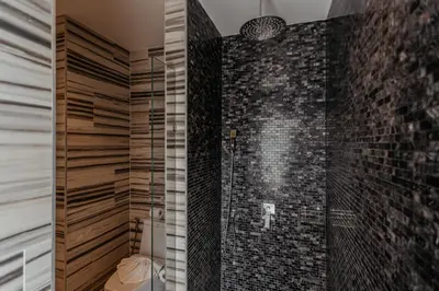 a bathroom with a walk in shower next to a brick wall at Tropical Haven 4 Bedroom Pool Villa in Bang Tao Beach