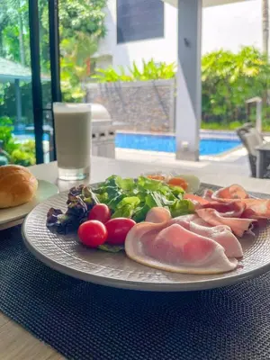 a plate of food with meat and vegetables on a table at Tropical Haven 4 Bedroom Pool Villa in Bang Tao Beach