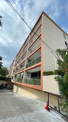 a large apartment building with a red at Rawai beach condominium Phuket in Nai Harn Beach