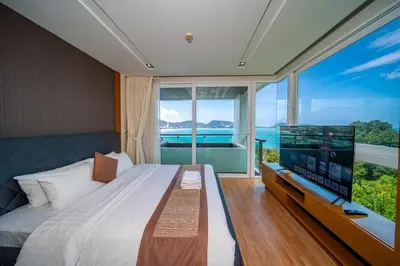a bedroom with a large bed with a large window at Patong Kalim Unparalleled Sea View B&B Resort in Patong Beach