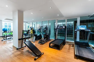 a gym with several treadmills and elliptical machines at Patong Kalim Unparalleled Sea View B&B Resort in Patong Beach