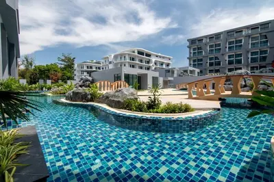 a swimming pool with a bridge in front of a building at Pool Access Utopia Loft, just 10 min from Nai Harn Beach, UTL A116 in Rawai Beach