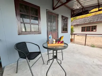 a table and a chair on a patio at Baan Ni Khun in Ban Lo Ti Pa (1)