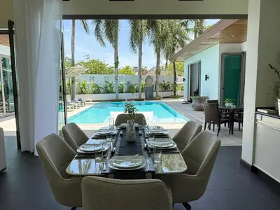 a dining room with a table and chairs and a pool at Pool Villa - 3 Bedroom- Walking to Bangtao Beach, Restaurants and Supermarkets in Bang Tao Beach