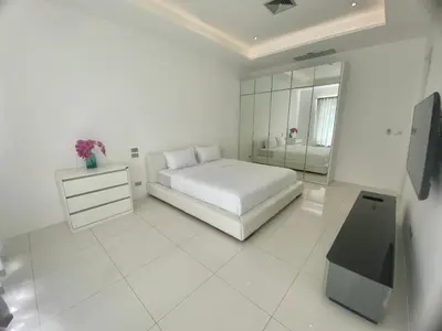 a white bedroom with a white bed and a bathroom at The View Luxury Condominium Karon in Kata Beach