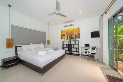 a bedroom with a bed and a desk and a computer at 3 bedrooms private villa with garden Rawai in Phuket Town