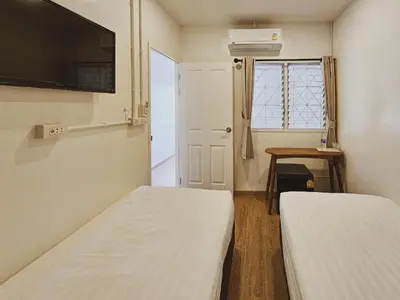 a small room with two beds and a window at Casa Maya House in Phi Phi Don