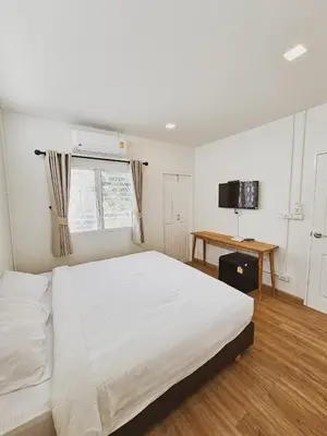 a bedroom with a large white bed and a desk at Casa Maya House in Phi Phi Don