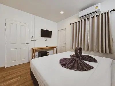 a bedroom with a bed with a brown ribbon on it at Casa Maya House in Phi Phi Don