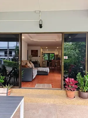 a living room with sliding glass doors and a couch at Grand Luxe Kamala in Kamala Beach