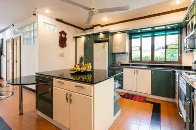 a kitchen with green cabinets and a bowl of fruit on the counter at 4-5 bedroom Villa At Kamala Beach, Pool in Kamala Beach