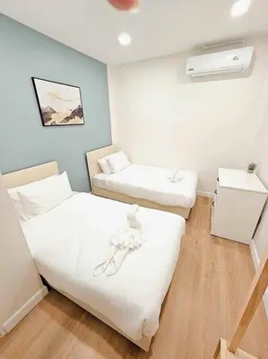 a room with two beds in a room with aperature at Baan 112 Patong in Patong Beach