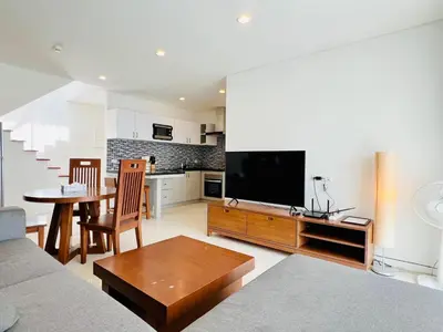 a living room with a couch and a tv and a table at Kamala Regent by RESAVA in Kamala Beach