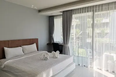 two stuffed animals sitting on a bed in a bedroom at At the Tree bright studio by Lofty in Rawai Beach