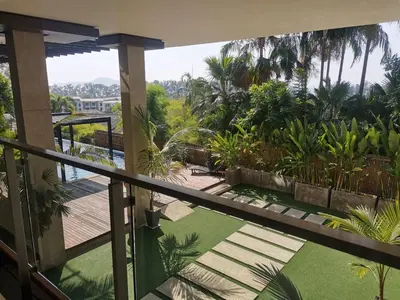 a balcony with a view of a garden at At the Tree bright studio by Lofty in Rawai Beach
