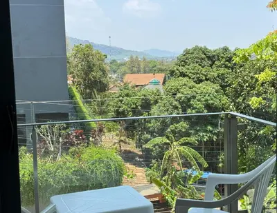 a balcony with a view of a garden at At the Tree bright studio by Lofty in Rawai Beach