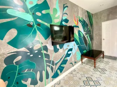 a living room with a colorful wall with a tv at Studio Apartment 12 in Thalang in Ban Phak Chit