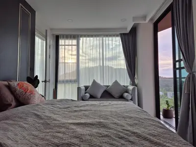 a bedroom with a large bed and a large window at The viva patong condo C602 in Patong Beach