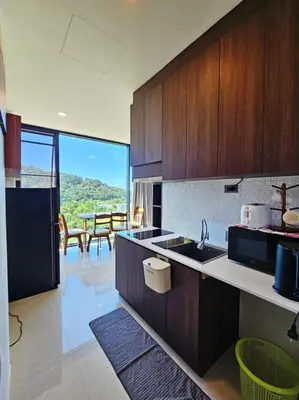 a kitchen with wooden cabinets and a view of a table at The viva patong condo C602 in Patong Beach