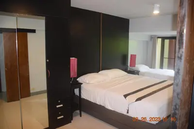 a bedroom with a large bed and a mirror at Kalim Residence in Patong Beach