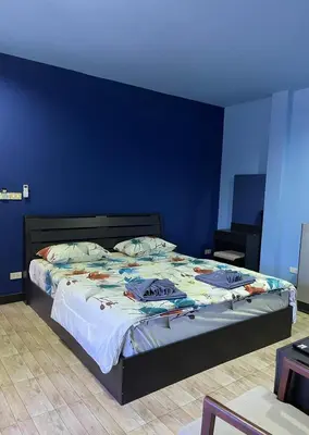 a bedroom with a bed with a blue wall at Mipiace in Kamala Beach