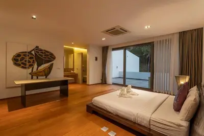 a bedroom with a bed and a table and a large window at Do You Want Luxury Sea views With Beach Access V38 in Rawai Beach