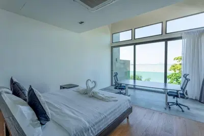 a bedroom with a bed and a desk and windows at Do You Want Luxury Sea views With Beach Access V38 in Rawai Beach