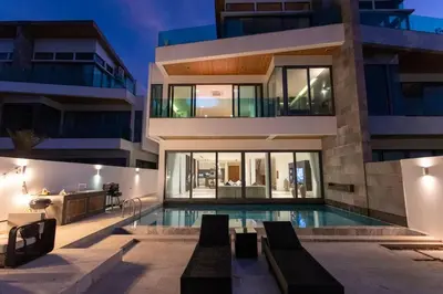 a house with a swimming pool in front of a building at Do You Want Luxury Sea views With Beach Access V38 in Rawai Beach