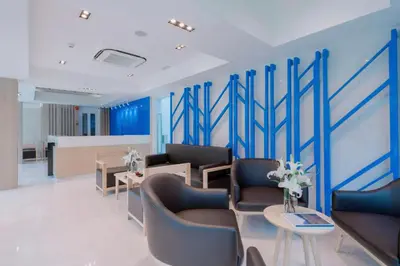 a waiting room with blue walls and couches and tables at Cozy Studio Rawai Beach Phuket in Ban Saiyuan (1)