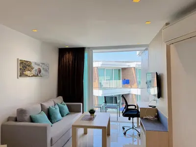 a living room with a couch and a table at Cozy Studio Rawai Beach Phuket in Ban Saiyuan (1)