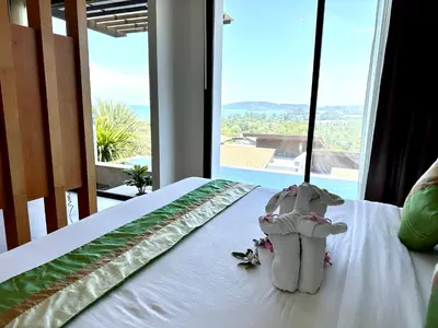 two stuffed animals sitting on a bed in a room with a window at 208 Ao Nang, Private Sea View Pool Villa in Krabi town