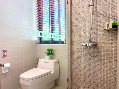 a bathroom with a toilet and a shower with a window at 208 Ao Nang, Private Sea View Pool Villa in Krabi town