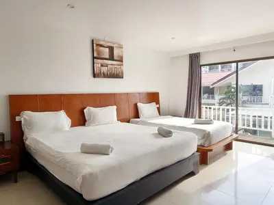 a bedroom with two beds and a window at V Beach Resort in Patong Beach