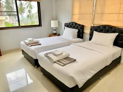 two beds sitting next to each other in a bedroom at Kata Vista Luxury Modern 4BR Private Pool Villa in Kata Beach