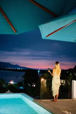 a woman in a white dress standing next to a pool at Phuket 4-6 Bedroom Seaview Villa Infinity 25mPool In-Villa Dining & Butler Gym in Thalang